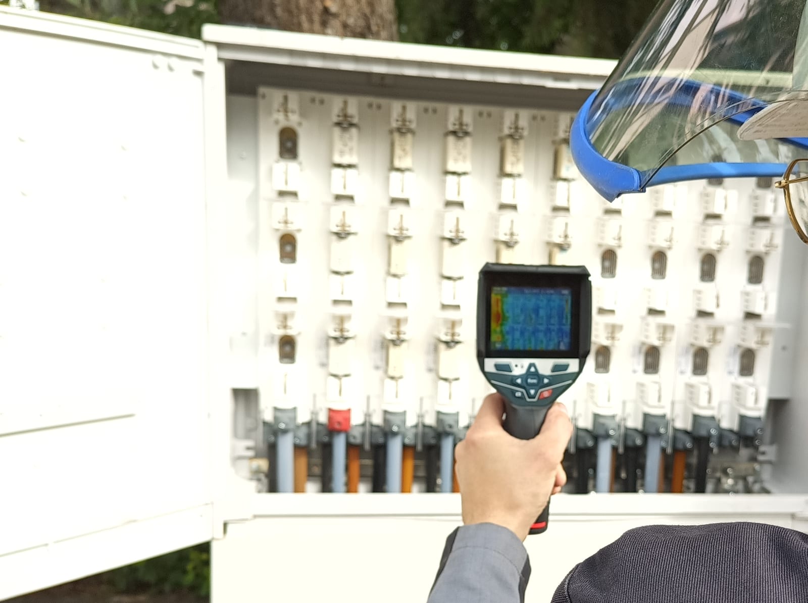 Thermografiekamera wird auf eine geöffnete Niederspannungsverteilung gerichtet