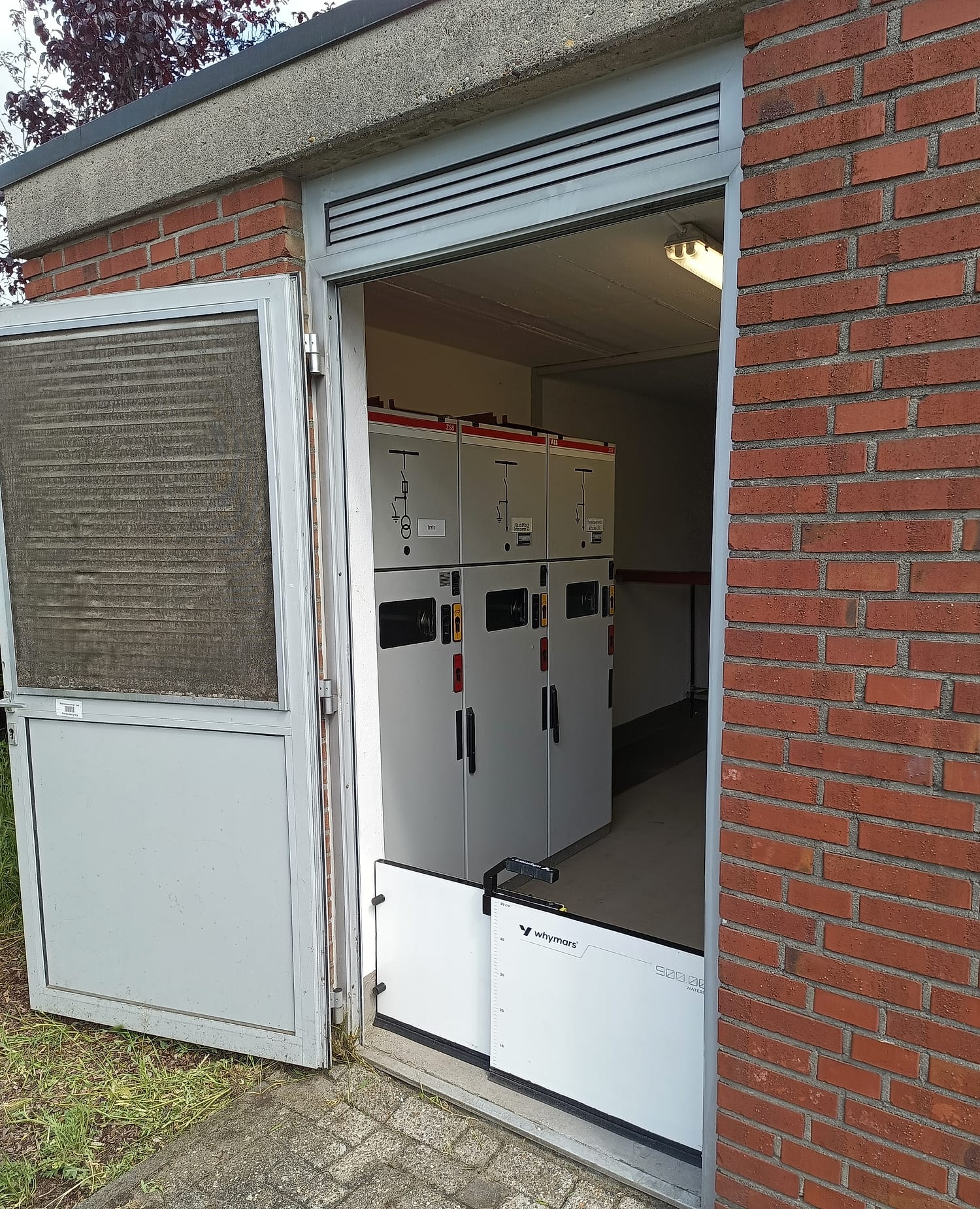 Mittelspannungsschaltanlage und Transformator im Inneren der Station. Der mobile Schutz an der Tür verhindert, dass Wasser überhaupt erst an diese Anlagentechnik gelangt.